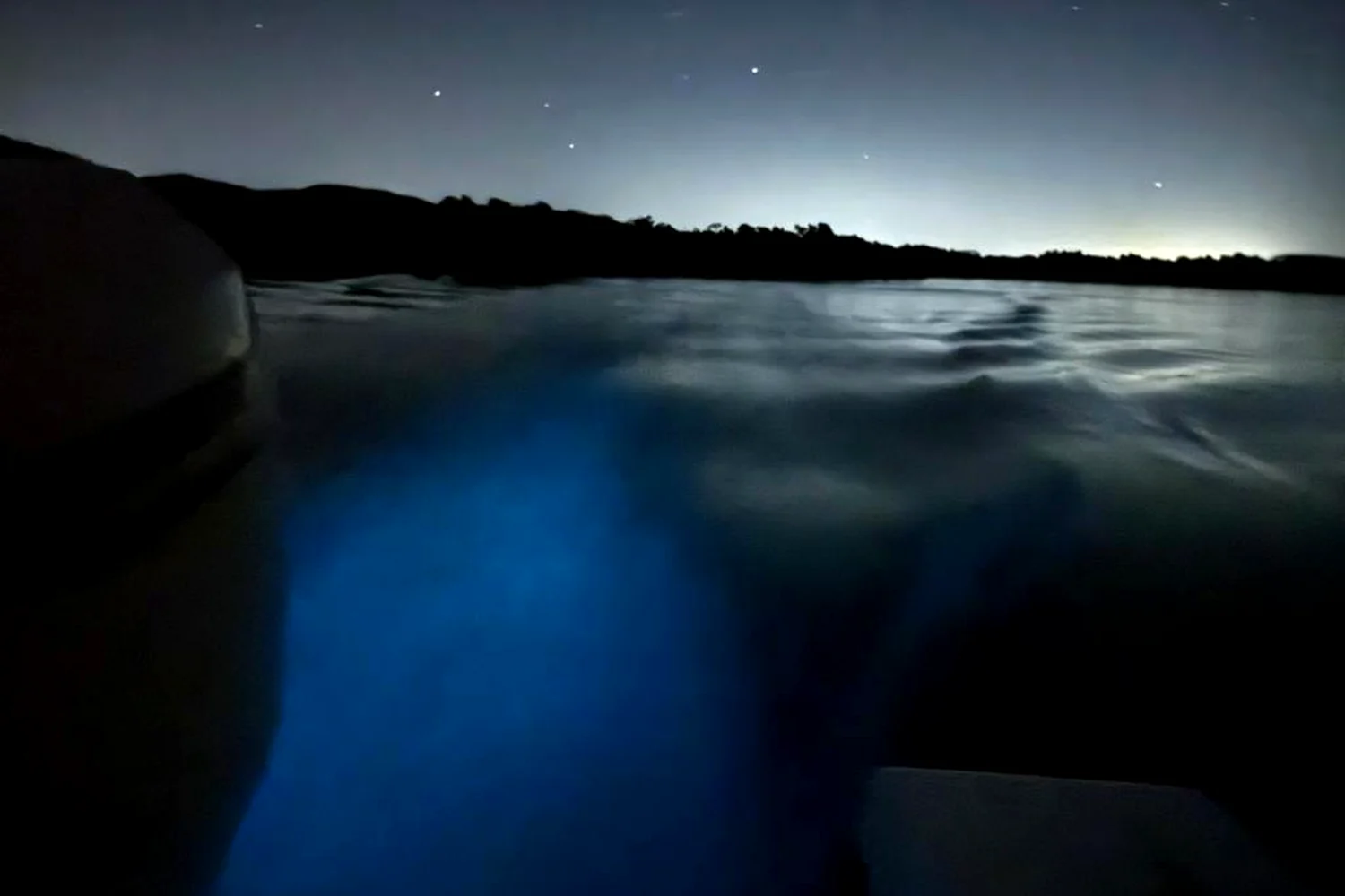 Blue bioluminescent glow in the water